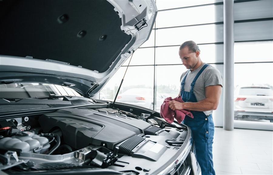 Profissional fazendo limpeza técnica no cofre do motor